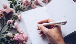 Woman is holding a pen to write in a daily planner