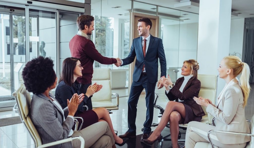 man promoted at work; colleagues congratulating him - ee220319