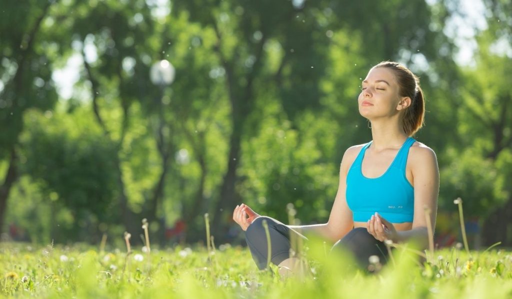 woman meditating at the park - ee220319