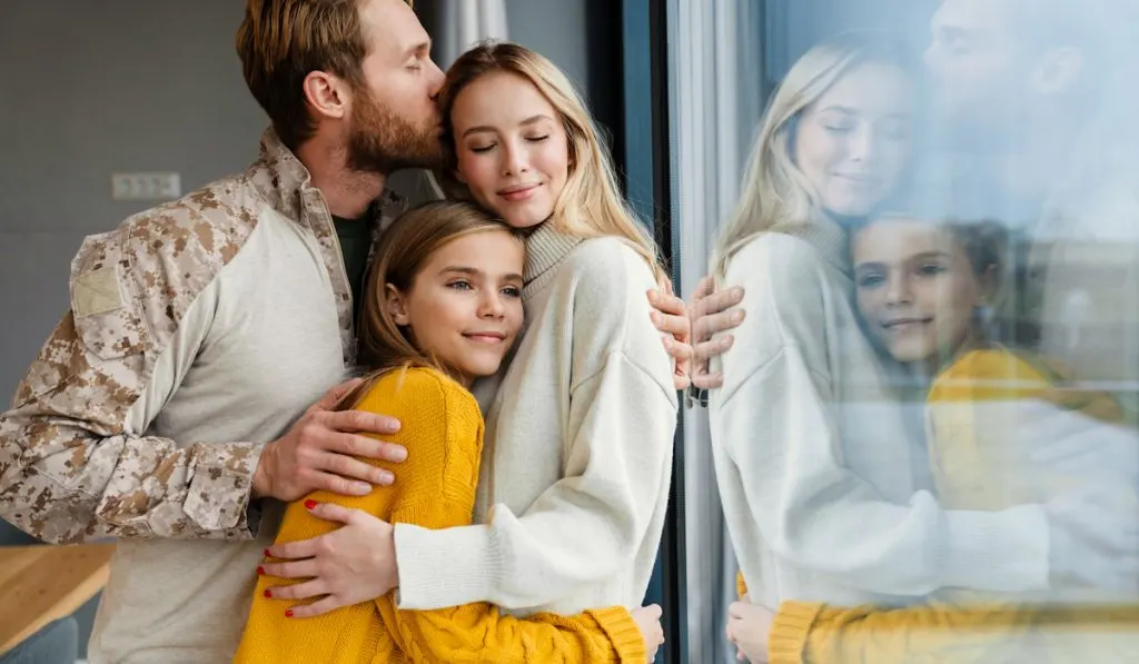 Beautiful happy young family hugging and kissing 