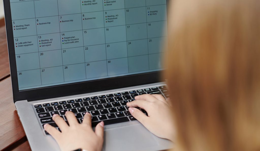 Entrepreneur Filling Calendar on Laptop