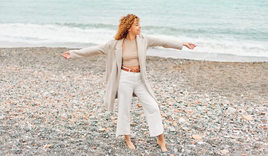 Happy curly woman on the beach 