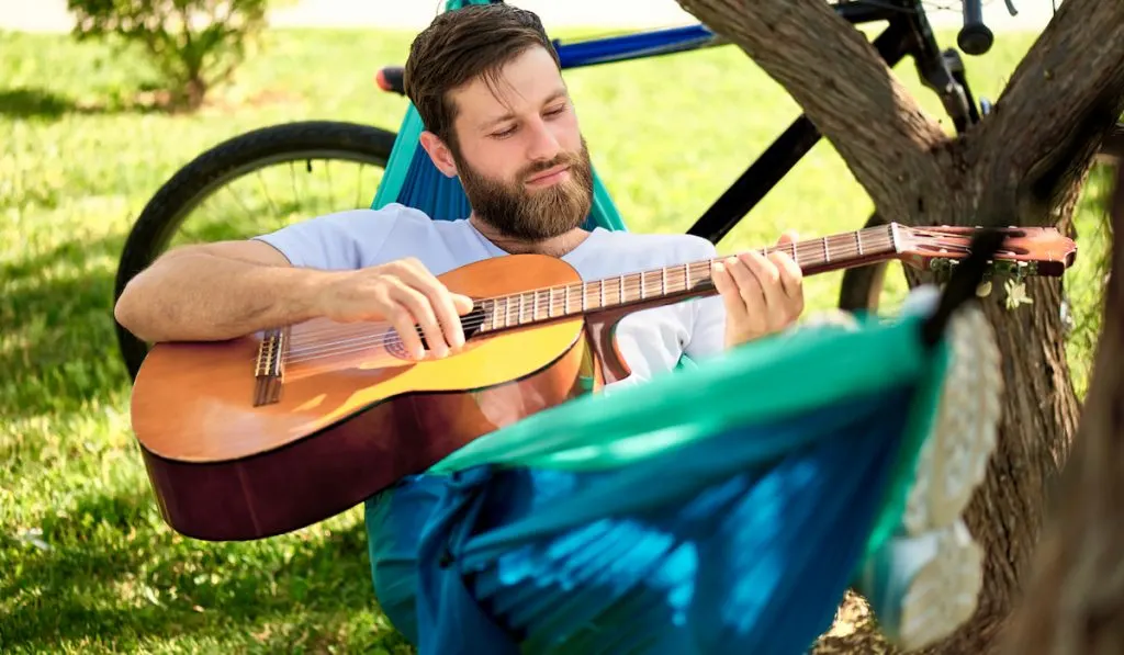 Man Playing guitar in a hammock