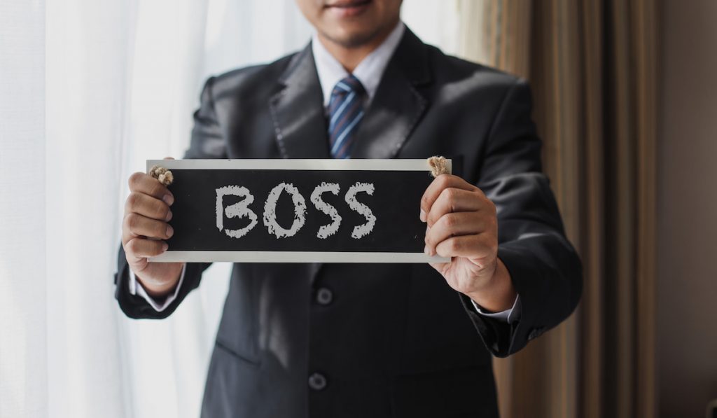 Man boss holding signage indicating the word boss 