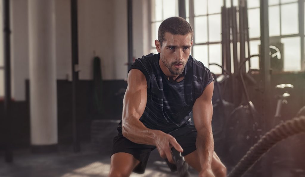 Man doing crossfit exercise with rope