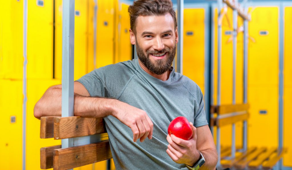 Man with apple in the gym