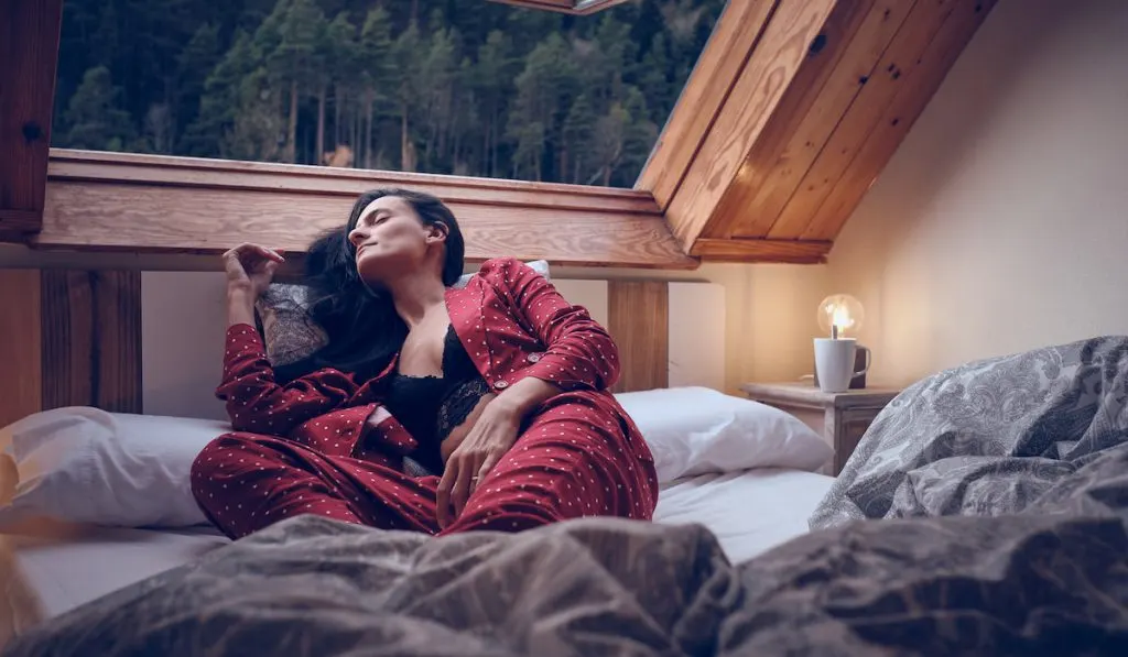 Woman sleeping in bed in cottage in highlands