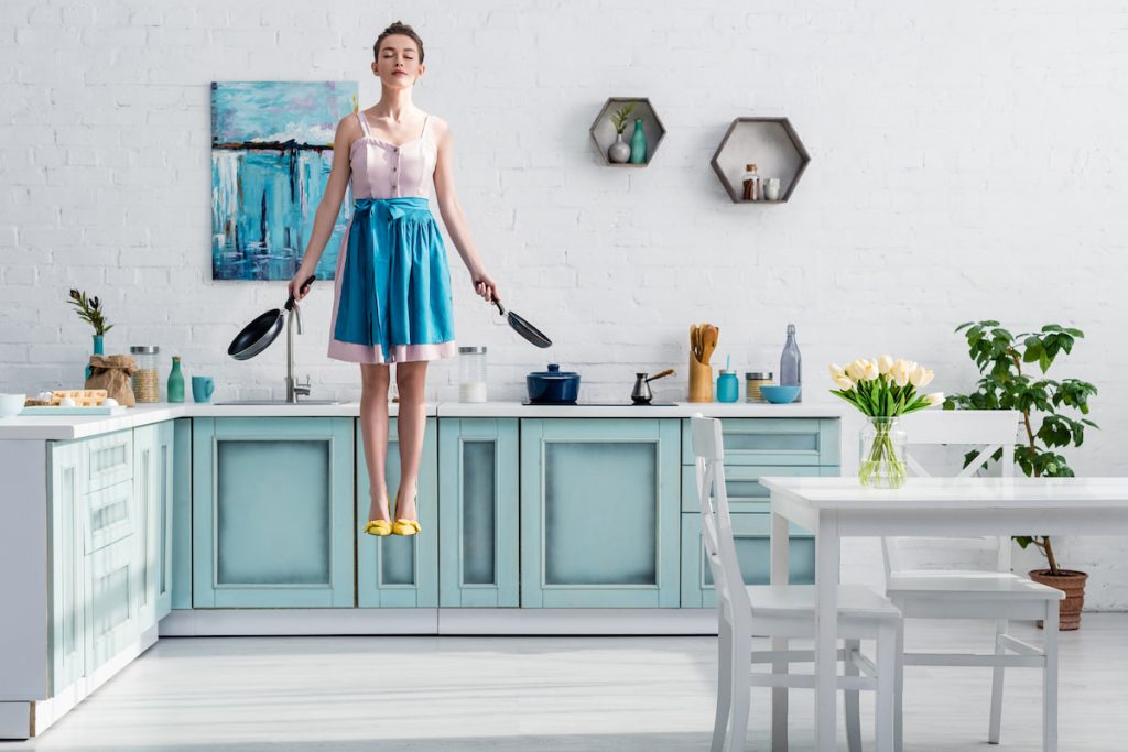 beautiful lady in dress dreaming floating in the kitchen 