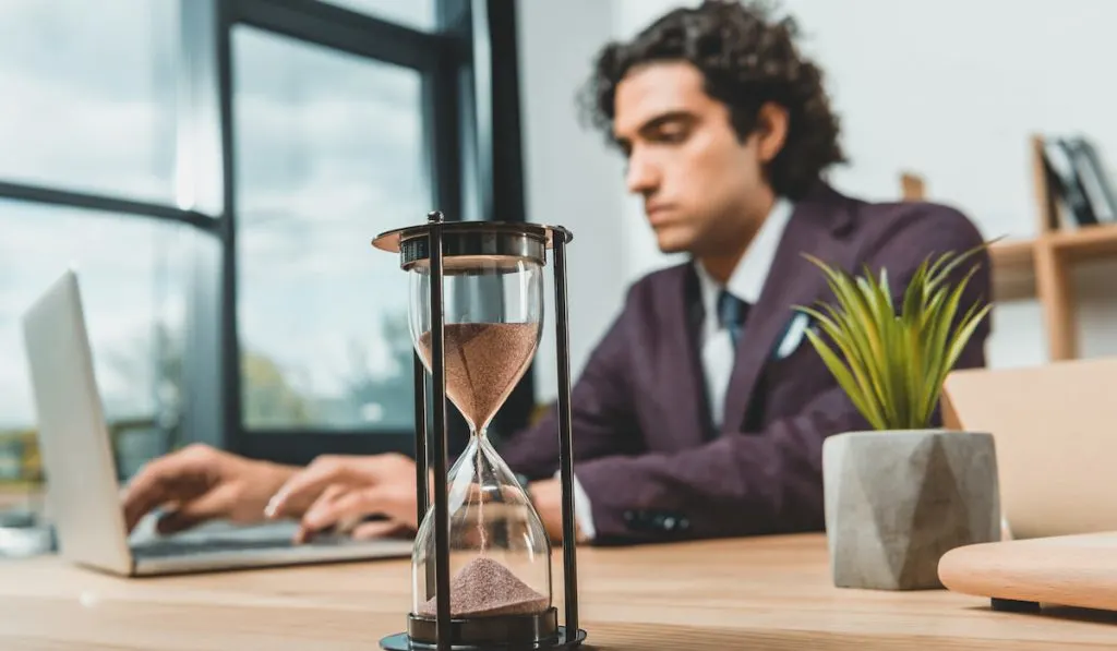 businessman typing on laptop while struggling to meet deadlines