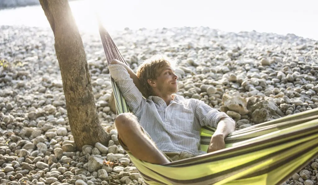content man relaxing in hammock on the beach 