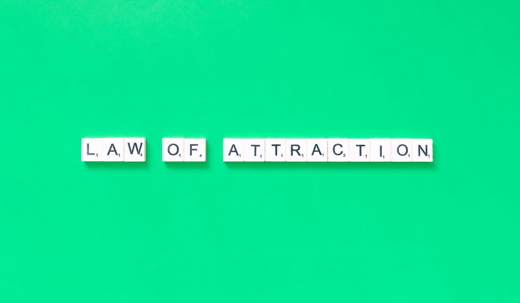 law of attraction quote in a green backround