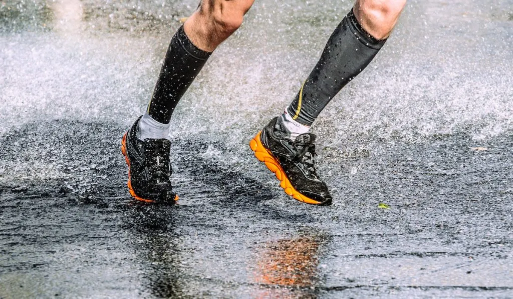 legs of runner athlete wearing compression socks 