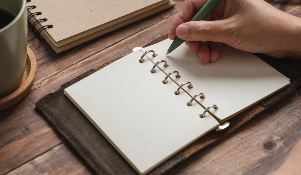 open blank planner on wooden working desk