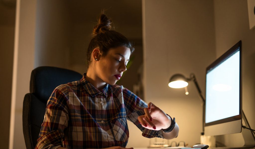 woman checking time in front of a computer