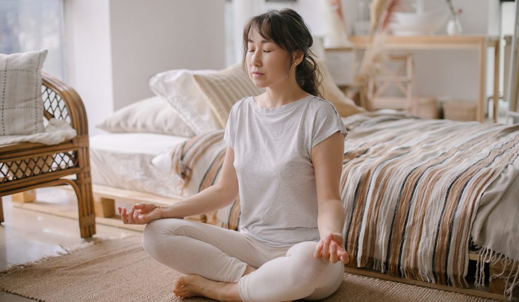 woman in lotus position meditation at home