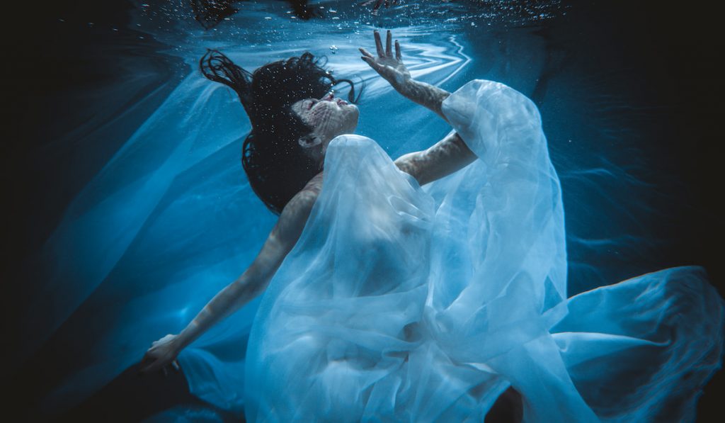 woman sleeping dreaming herself underwater 