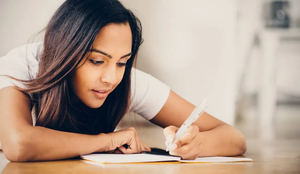 young woman writing on her notebook